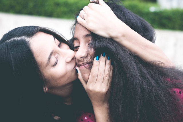 parent kissing child's cheek, eva carlston academy 