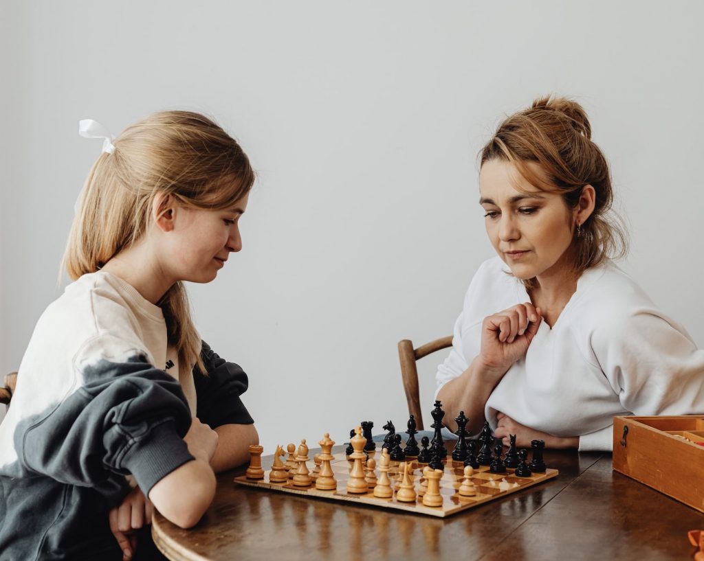 Teenager and mom playing chess