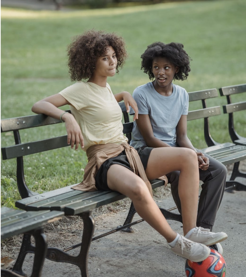 Two teenage girls sitting on a bench