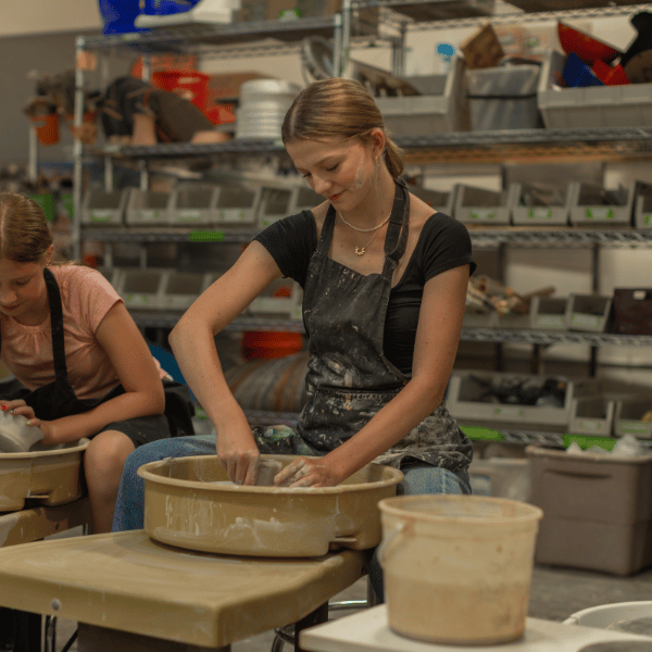 Creative Expression for Student Growth at Eva Carlston Academy: Students engage in pottery, shaping clay on the wheel to develop skills, focus, and personal growth in a creative environment.