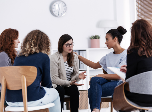 A group therapy session where women support each other, addressing challenges related to teen substance abuse and mental health myths.