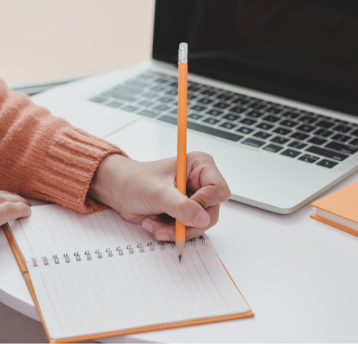 Parent journaling near a laptop as part of a daily routine for family stress relief