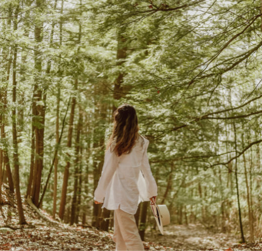 Young person experiencing emotional growth through nature for teens while walking quietly through a forest.
